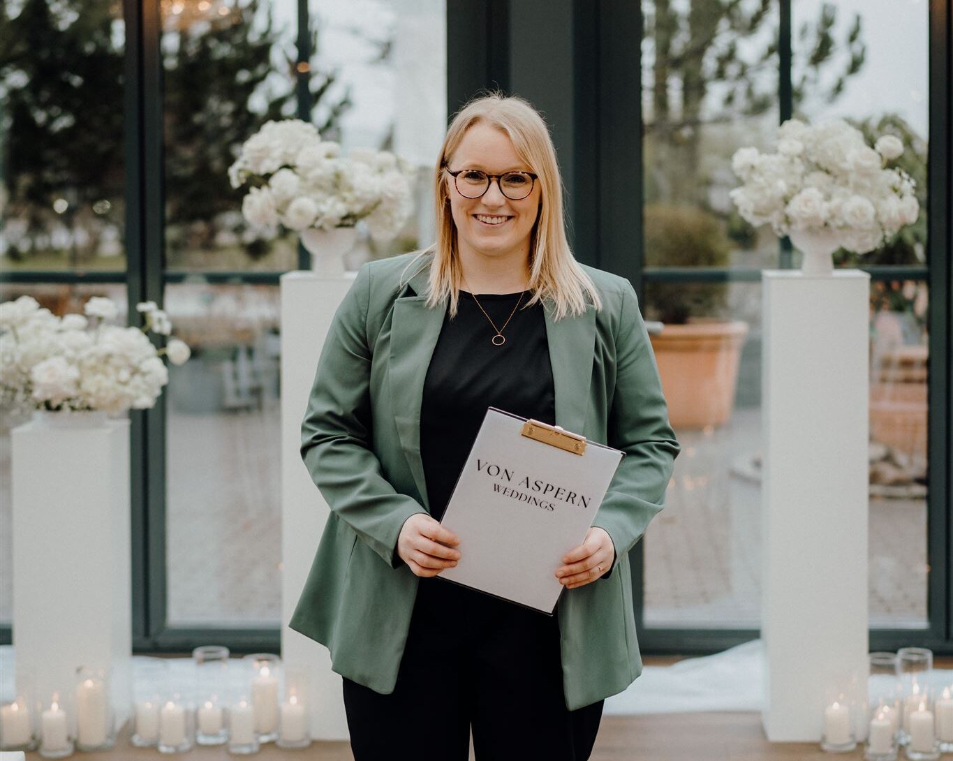 Hochzeitsplanerin Sophia steht vor Trauungssetup in der Glashütte in Adendorf