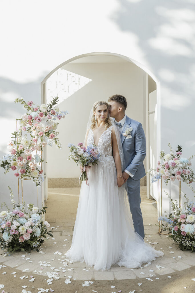 Bräutigam küsst Braut auf Hinterkopf, Planung: von Aspern Weddings