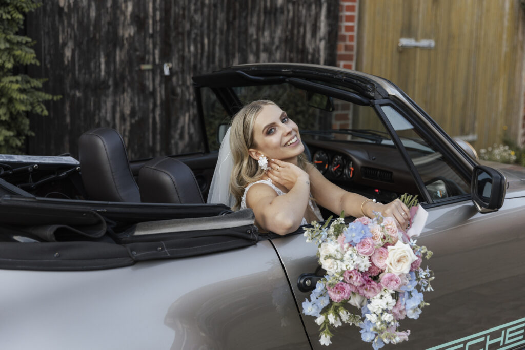 Braut im Porsche mit Brautstrauß, Planung: von Aspern Weddings
