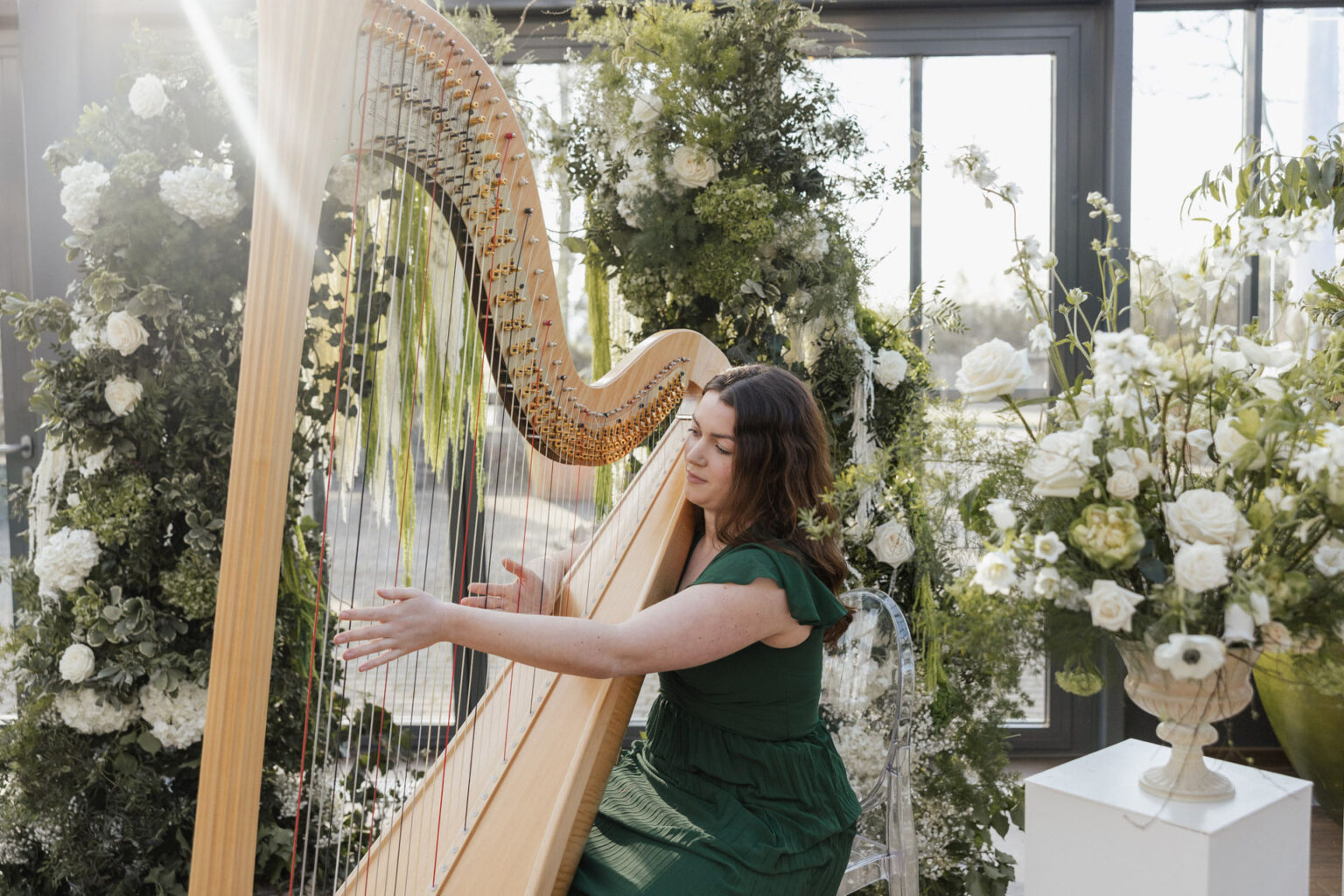 Opulente Blumengestecke umrahmen die Harfinistin, die auf ihrer Harfe spielt, Planung: Sophia von Aspern, von Aspern Weddings, Lüneburg, Hamburg, Hannover, Bremen