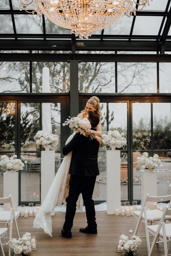 Braut wird von Bräutigam in die Luft gehoben zwischen Trauungssetup, Planung: Sophia von Aspern, von Aspern Weddings, Lüneburg, Hamburg, Hannover, Bremen