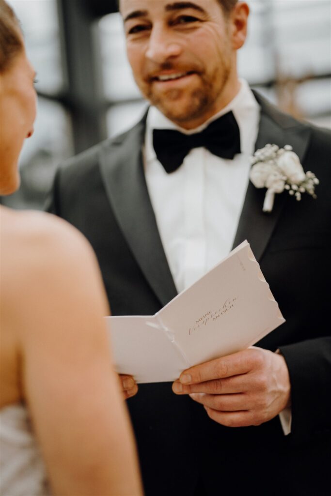 Bräutigam hält das Eheversprechen in den Händen und lächelt, Planung: Sophia von Aspern, von Aspern Weddings, Lüneburg, Hamburg, Hannover, Bremen