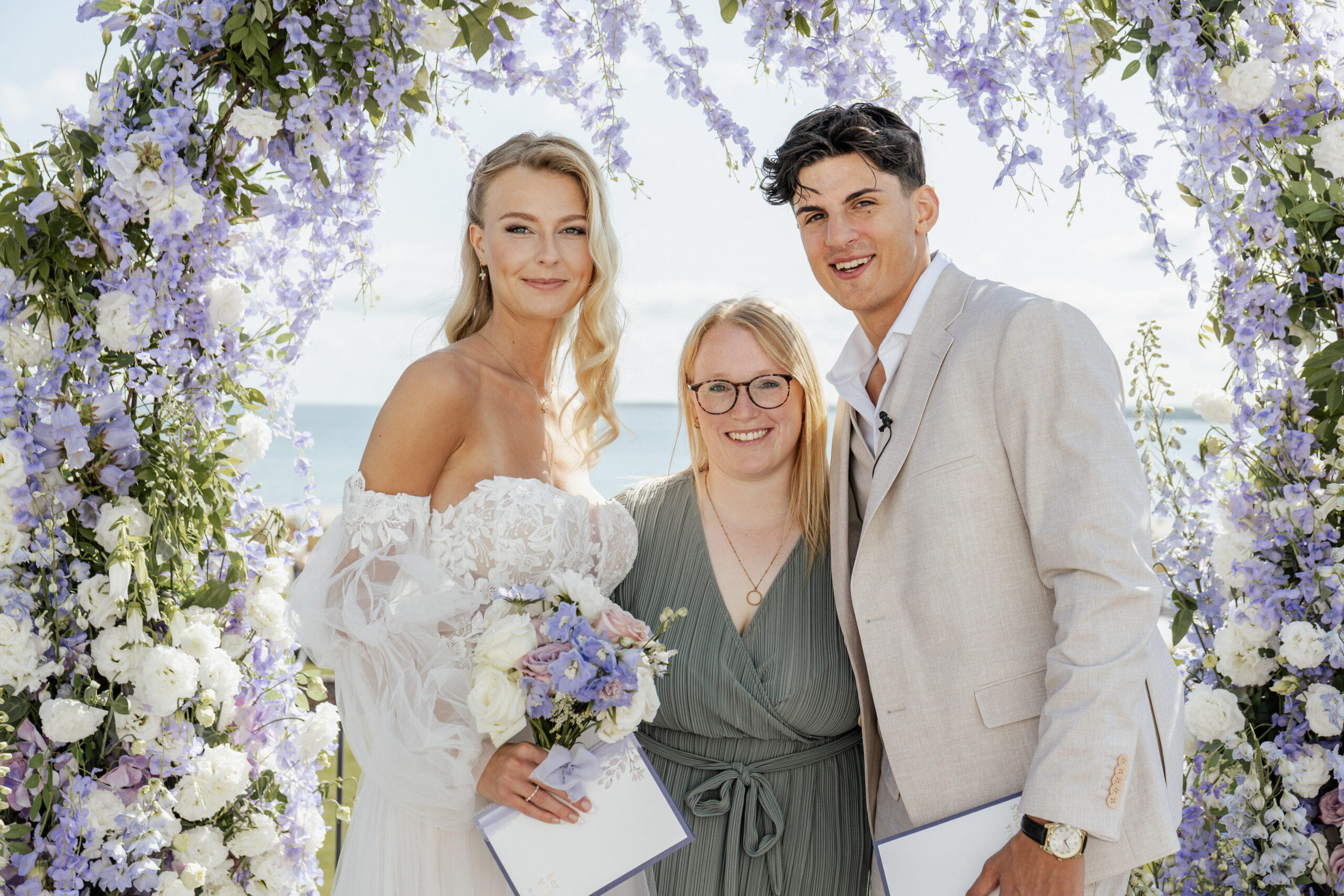 Brautpaar gemeinsam mit Hochzeitsplanerin Sophia von Aspern unter einem festlich geschmückten Traubogen – liebevoll begleitet durch von Aspern Weddings | Hamburg, Bremen, Hannover, Niedersachsen.