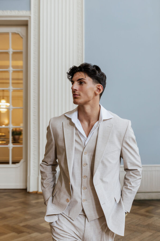 Bräutigam steht im festlich dekorierten Hochzeitssaal des Atlantic Hotels Travemünde, elegante Hochzeitsplanung Sophia von Aspern, von Aspern Weddings, Hamburg, Bremen, Hannover, Niedersachsen.