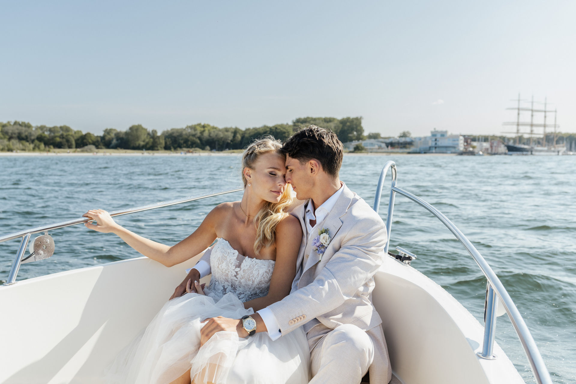 Brautpaar genießt die Fahrt auf einem Boot auf der Ostsee vor dem Atlantic Grand Hotel Travemünde – stilvolle Hochzeitsplanung mit Sophia von Aspern und von Aspern Weddings in Hamburg, Bremen, Hannover und Niedersachsen.