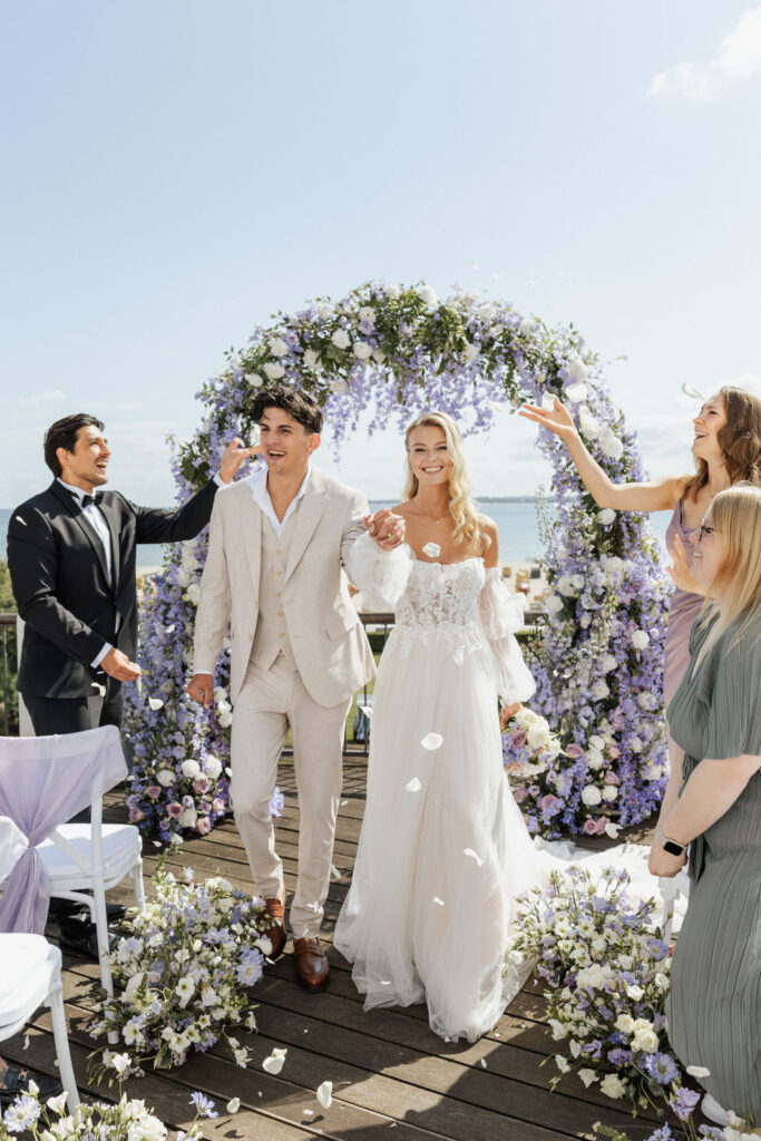 Brautpaar sagt Ja vor Ostseekulisse im Atlantic Hotel Travemünde, festlich geschmückter Traubogen, Hochzeitsplanung mit Sophia von Aspern, von Aspern Weddings, Hamburg, Schleswig-Holstein, Bremen.