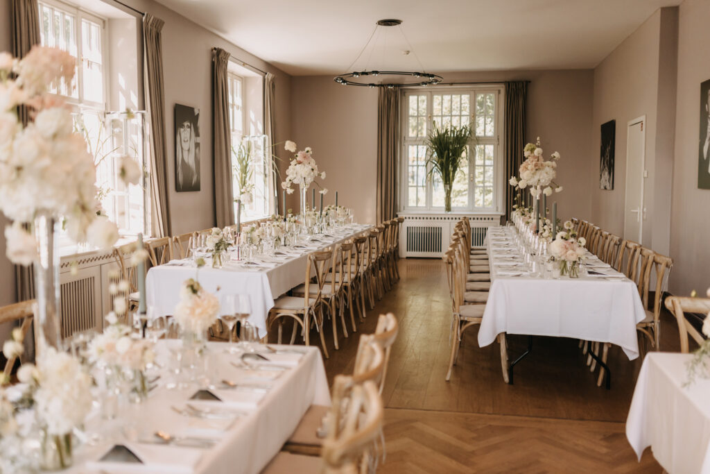 Edler Innenraum der Villa im Heinepark als Hochzeitslocation in Hamburg, festlich gedeckt für ein exklusives Hochzeitsdinner. Zeitloses Design trifft auf elegante Hochzeitsplanung von Sophia von Aspern. Heiraten an der Elbe mit von Aspern Weddings für Paare aus Hamburg, Bremen, Hannover und Niedersachsen.