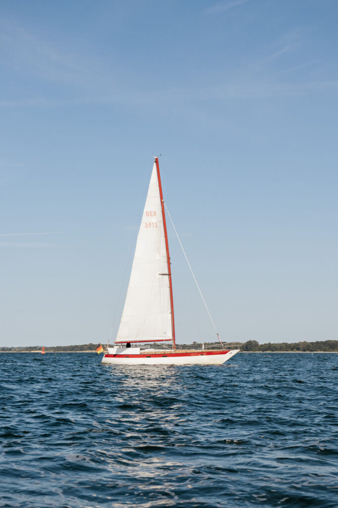 Yacht des Brautpaars vor der Küste Travemündes auf der Ostsee, exklusive Hochzeitsplanung Sophia von Aspern, von Aspern Weddings, Hamburg, Bremen, Hannover, Niedersachsen.