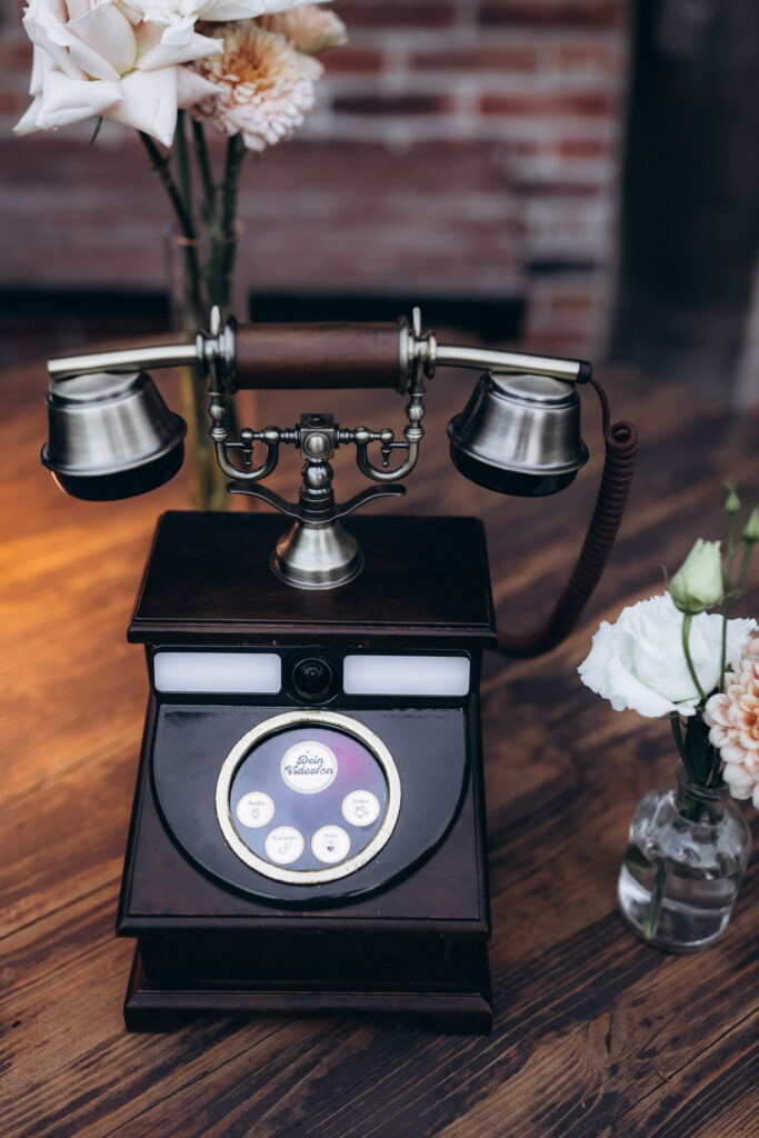 Gäste nehmen auf der Hochzeitsparty Videobotschaften mit dem Videogäste-Telefon auf – von Aspern Weddings, Hamburg.