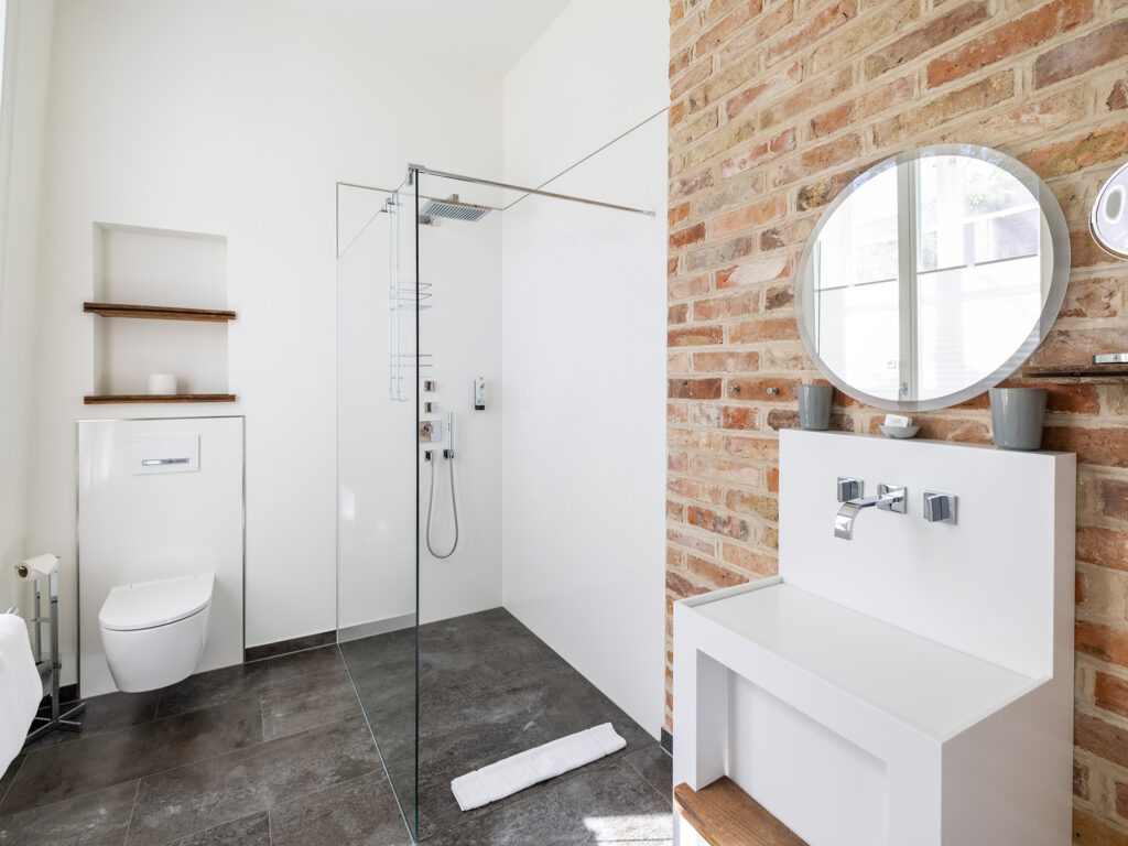 Modernes Badezimmer im Deluxedoppelzimmer im Wyndberghotel Lüneburg mit klaren Linien, hochwertiger Ausstattung und viel Platz für entspannte Hochzeitsvorbereitungen. Stilvolle Umgebung innerhalb der Hochzeitslocation in Lüneburg, ideal für Getting ready Momente im Rahmen der Hochzeitsplanung mit Sophia von Aspern und von Aspern Weddings, passend für Paare aus Hamburg, Bremen, Hannover und Niedersachsen.