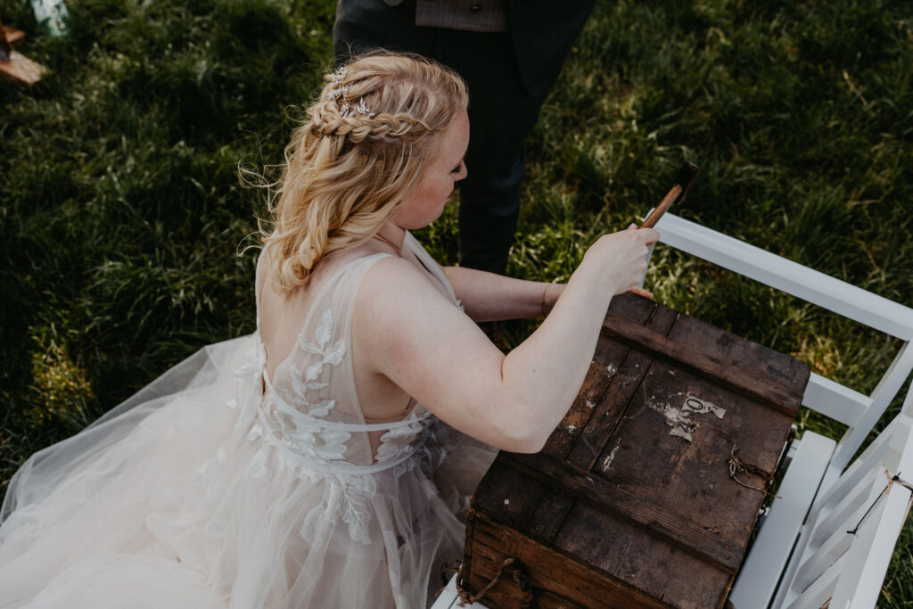 Bei einer freien Trauung in Hamburg steht eine Holz-Zeitkapsel im Mittelpunkt, in die Gäste während der Zeremonie handgeschriebene Zettel mit Wünschen und Erinnerungen legen. Das Brautpaar schließt die Kiste gemeinsam mit einem Nagel als symbolischen Moment der Verbundenheit. Emotionales Trauritual mit persönlicher Bedeutung, umgesetzt im Rahmen einer stilvollen Hochzeitsplanung von Sophia von Aspern. Natürliche Materialien, ruhige Atmosphäre und intime Stimmung, passend für moderne Hochzeiten in Hamburg, Hannover, Bremen und Niedersachsen. Konzeptidee aus dem Bereich Hochzeitsplanung von Aspern Weddings.