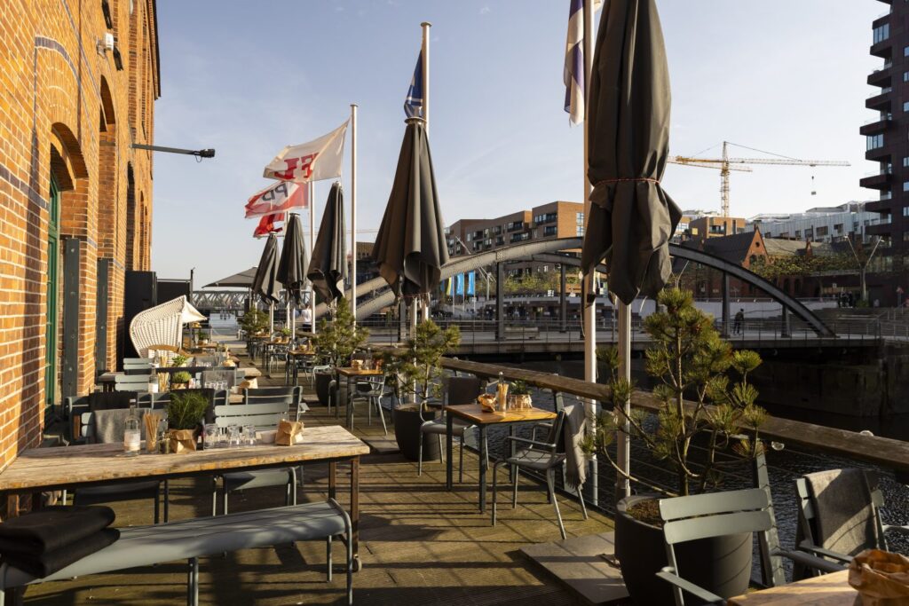 Außenbereich und Terrasse des Restaurants Catch of the Day in der Hamburger HafenCity mit Blick aufs Wasser, modernem maritimem Stil und stilvoller Atmosphäre, besondere Hochzeitslocation in Hamburg für exklusive Feiern im Freien, Hochzeitsplanung in Hamburg, Bremen, Hannover und Niedersachsen, begleitet von Sophia von Aspern, von Aspern Weddings.