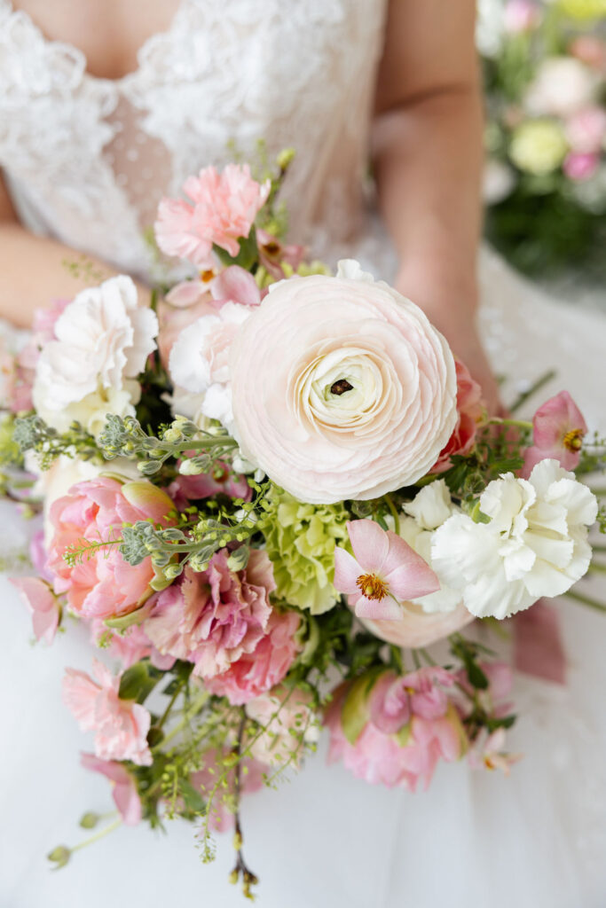 Braut hält den Brautstrauß in der Hand, Fokus auf die Blumen mit Kombination aus Lime und Rose, harmonische Farbgestaltung für eine moderne Hochzeit in Hamburg, Bremen und Hannover, geplant von Sophia von Aspern von Aspern Weddings