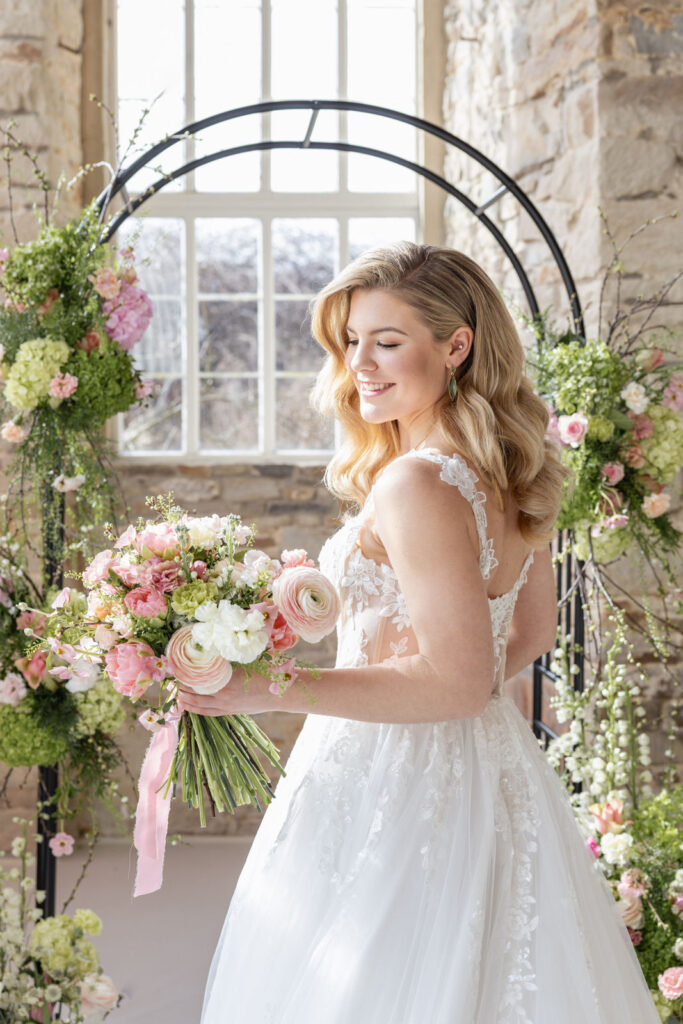 Braut mit Brautstrauß vor floralem Traubogen von Ivy and Rose bei einer stilvollen freien Trauung, inspiriert für exklusive Hochzeitsplanung in Hamburg, Bremen, Hannover und Niedersachsen von Aspern Weddings Sophia von Aspern.