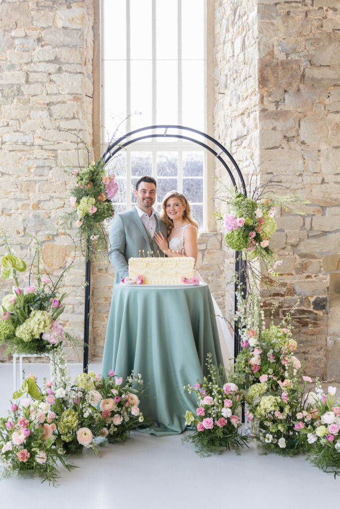 Brautpaar steht hinter der Hochzeitstorte und pustet gemeinsam die Kerzen aus, ein emotionaler Moment während der Feier. Stilvolle Hochzeitsplanung von Sophia von Aspern für exklusive Hochzeiten in Hamburg, Bremen, Hannover und Niedersachsen.