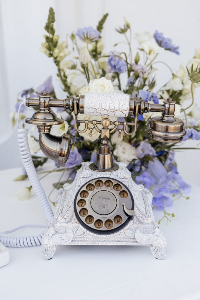 Audiogästebuch auf einer Hochzeit: Ein nostalgisches Telefon steht bereit und die Hochzeitsgäste sprechen persönliche Glückwünsche, Erinnerungen oder kleine Botschaften für das Brautpaar ein. Das Audiogästebuch sorgt für Unterhaltung während der Feier und hält emotionale Stimmen der Gäste fest. Hochzeitsplanung in Norddeutschland mit Fokus auf Hamburg, Hannover, Bremen und Niedersachsen. Sophia von Aspern, von Aspern Weddings.