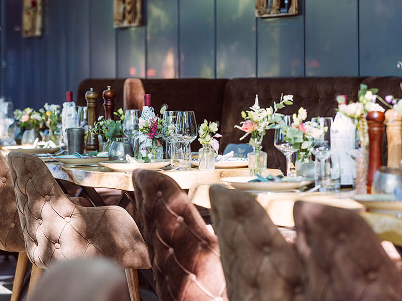 Tischsetting mit Blumen auf der Terrasse der Eppendorfer Insel in Hamburg, stilvolle Tischansicht in einer exklusiven Hochzeitslocation für moderne Hochzeitsplanung von Sophia von Aspern in Hamburg, Bremen, Hannover und Niedersachsen.