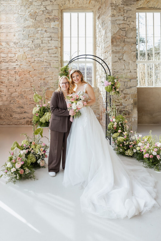 Hochzeitsplanerin Sophia von Aspern mit Braut Lea vor einem floralen Traubogen bei einer freien Trauung, inspirierend für exklusive Hochzeitsplanung in Hamburg, Bremen, Hannover und Niedersachsen mit von Aspern Weddings.