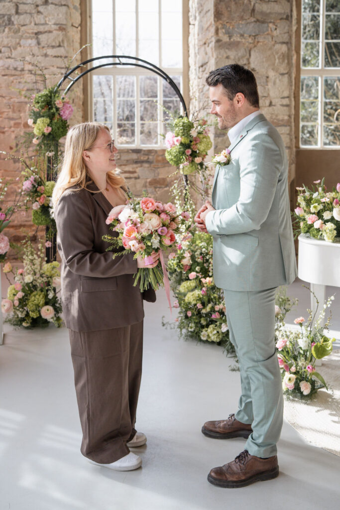 Sophia von Aspern unterhält sich mit dem Bräutigam und hält dabei den Brautstrauß in der Hand, während letzte Details der Hochzeit abgestimmt werden. Exklusive Hochzeitsplanung von von Aspern Weddings für stilvolle Hochzeiten in Hamburg, Bremen, Hannover und Niedersachsen.