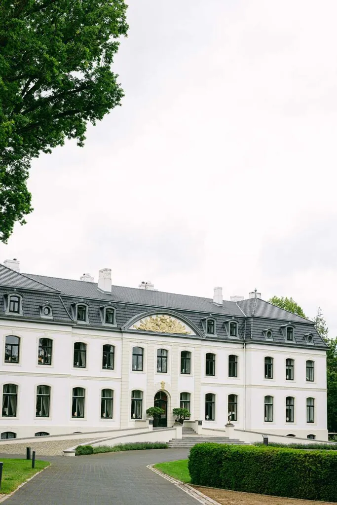 Außenansicht von Weissenhaus als exklusive Hochzeitslocation an der Ostsee mit besonderem Destinationwedding Gefühl, ideal für stilvolle Hochzeitsplanung in Hamburg, Bremen, Hannover und Niedersachsen von Aspern Weddings Sophia von Aspern.
