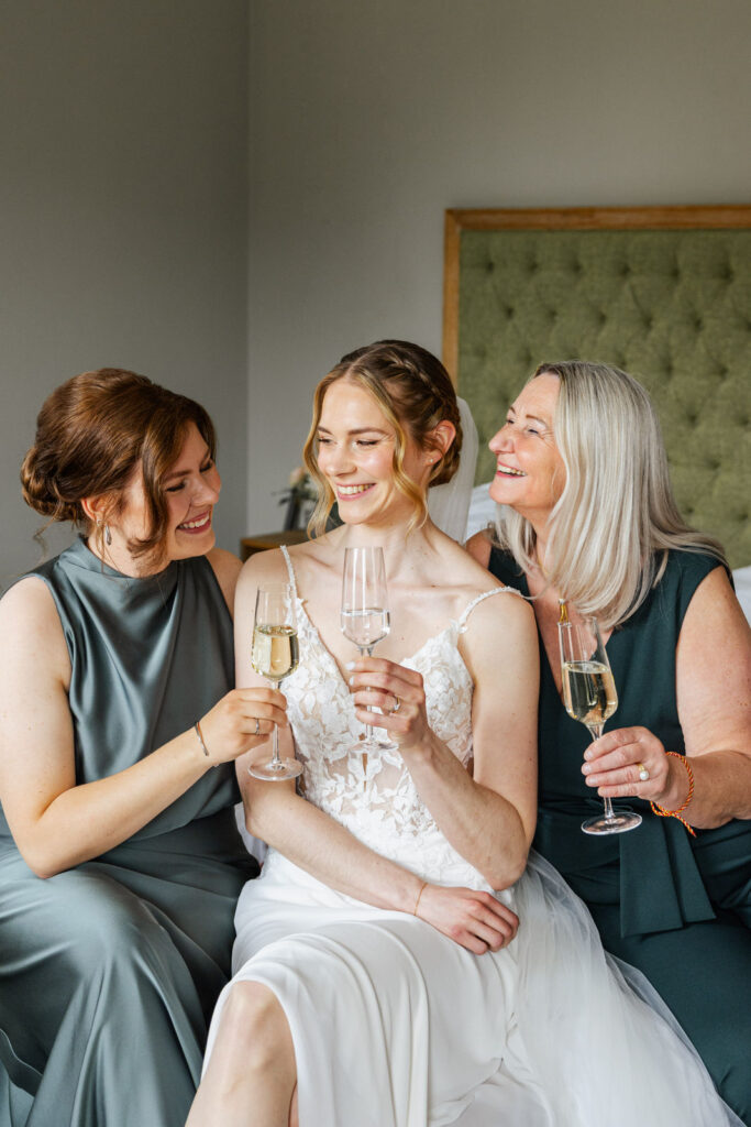 Braut Gesa mit ihrer Trauzeugin und ihrer Mutter beim Getting Ready im Hotel Gut Altona. Gemeinsam entstehen emotionale Momente während der Hochzeitsvorbereitungen in stilvoller Atmosphäre. Hochzeitsplanung in Hamburg, Bremen, Hannover und Niedersachsen. Sophia von Aspern, Hochzeitsplanung, von Aspern Weddings.