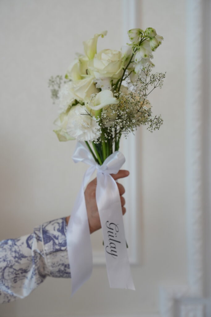Brautjungfernstrauß vor einer eleganten Stuckwand im Schloss Ovelgönne als stilvolles Detail einer exklusiven Hochzeit. Begleitet von Sophia von Aspern von von Aspern Weddings. Hochzeitsplanung in Niedersachsen, Hamburg, Bremen und Hannover.