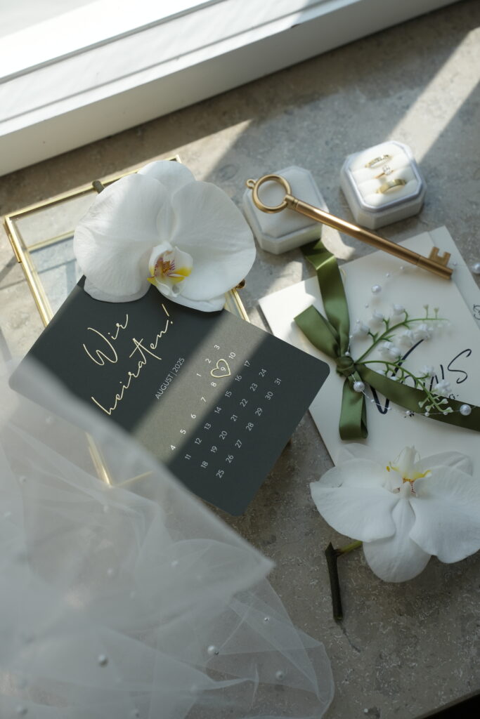 Flatlay von Einladungskarten mit Blüten im Schloss Ovelgönne als stilvolle Papeterie Inspiration für eine exklusive Hochzeit. Begleitet von Sophia von Aspern als Zeremonienmeisterin von von Aspern Weddings. Hochzeitsplanung in Hamburg, Bremen, Hannover und Niedersachsen.