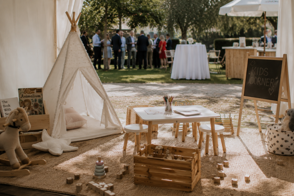Eine vorbereitete Spielecke auf einer Hochzeit mit Spielsachen, Sitzmöglichkeiten und Beschäftigungsangeboten für Kinder, aktuell ohne Kinder im Bild. Eine gut geplante Spielecke kann bei der Hochzeitsplanung in Hamburg, Bremen, Hannover und Niedersachsen für entspannte Familienmomente sorgen.
