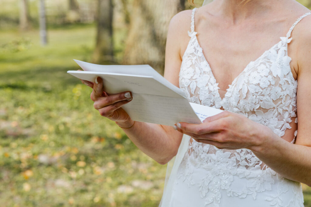 Braut hält beim First Look im Hotel Gut Altona einen Zettel mit ihrem persönlichen Eheversprechen in der Hand. Emotionaler Moment vor der Trauung bei der Hochzeitsplanung in Hamburg, Bremen, Hannover und Niedersachsen mit Sophia von Aspern.