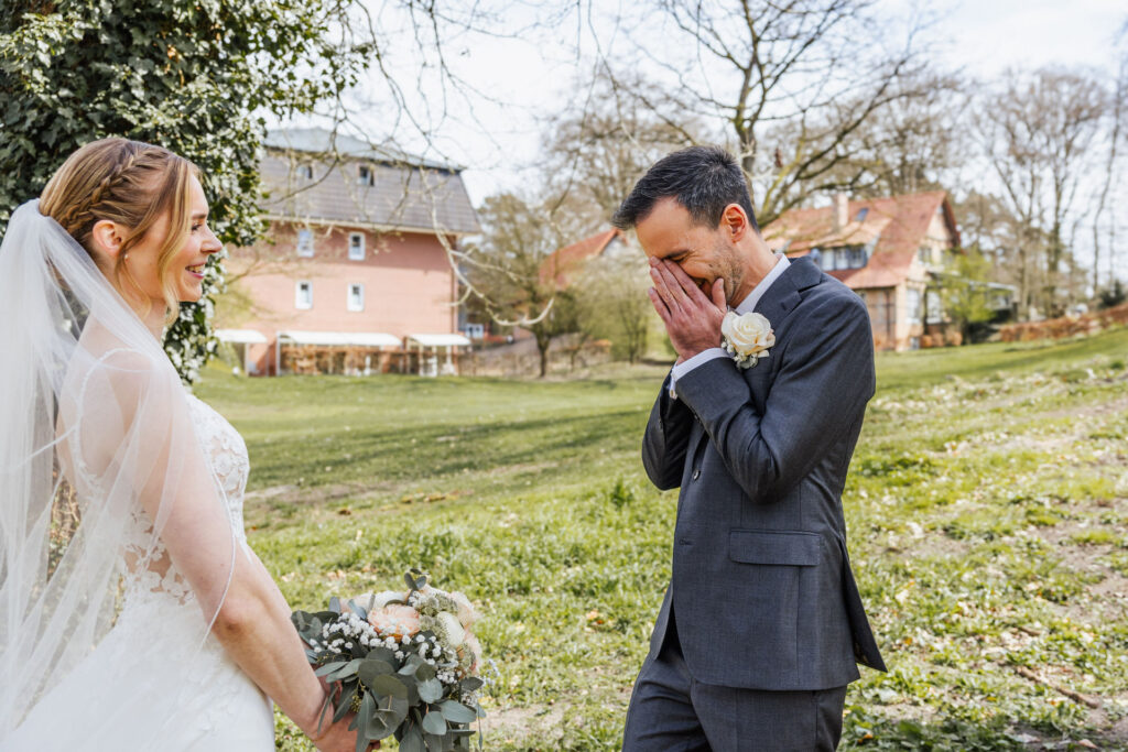 Bräutigam beim First Look auf einer Hochzeit vollkommen überwältigt vom Aussehen seiner Braut. Emotionaler Moment eines Hochzeitstrends bei der Hochzeitsplanung in Hamburg, Bremen, Hannover und Niedersachsen mit Sophia von Aspern.