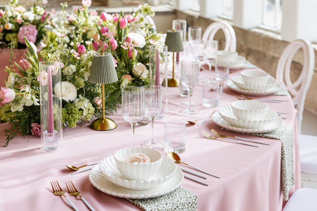 Stilvolles Tischsetting in der Orangerie Gut Ostenwalde mit rosaner Tischdecke und floraler Dekoration. Moderner Hochzeitstrend mit bunten Tischdecken für exklusive Hochzeiten in Hamburg, Bremen, Hannover und Niedersachsen mit Sophia von Aspern von Aspern Weddings.
