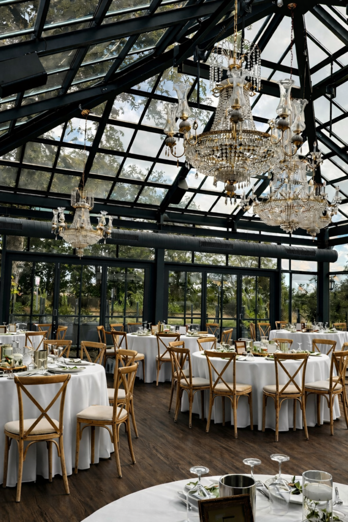 Hochwertiges Tischsetting in der Glashütte Adendorf mit bodenlangen Tischdecken, floraler Tischdekoration und Crossback Chairs als moderner Hochzeitstrend. Hochzeitsplanung in Hamburg, Bremen, Hannover und Niedersachsen von Sophia von Aspern.