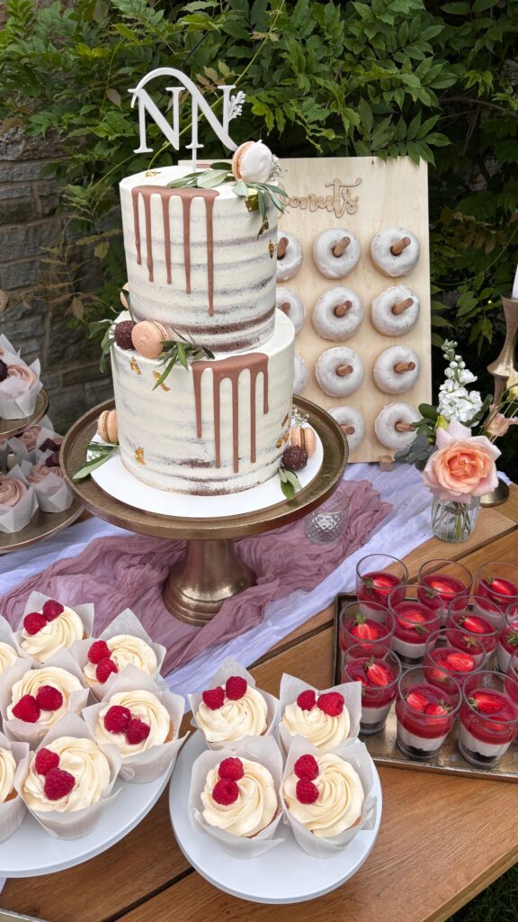 Detailaufnahme eines stilvollen Sweet Tables im Rittergut Remmeringhausen mit Hochzeitstorte, Donuts, Dessertgläsern, Macarons, Cupcakes, Cakepops und Cakecicles. Hochwertiges Dessertkonzept von Sanelas Tortenwelt als Inspiration für exklusive Hochzeiten und Hochzeitsplanung von Aspern Weddings in Hamburg, Bremen, Hannover und Niedersachsen.