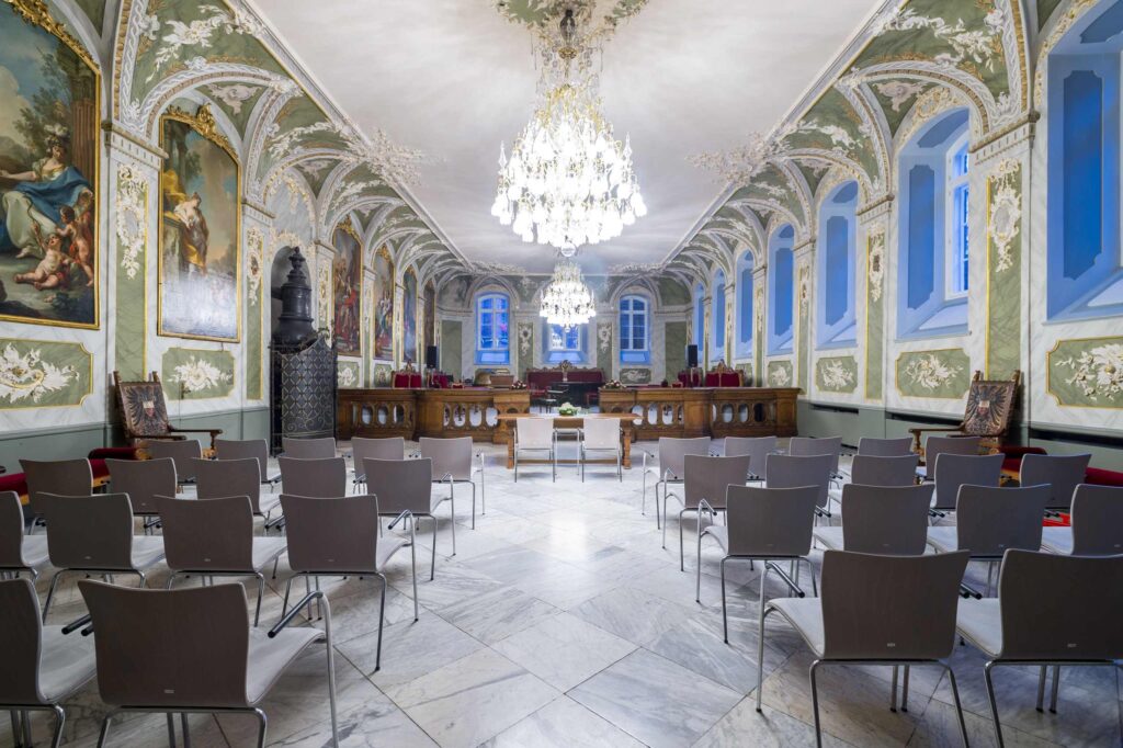 Gesamtansicht des Audienzsaals im Rathaus Lübeck. Der eindrucksvolle historische Trausaal des Standesamts Lübeck eignet sich für standesamtliche Trauungen mit bis zu 100 Gästen und überzeugt mit seiner repräsentativen Architektur. Hochzeitsplanung von Sophia von Aspern, von Aspern Weddings, für Hochzeiten in Lübeck, Hamburg, Bremen und Niedersachsen.