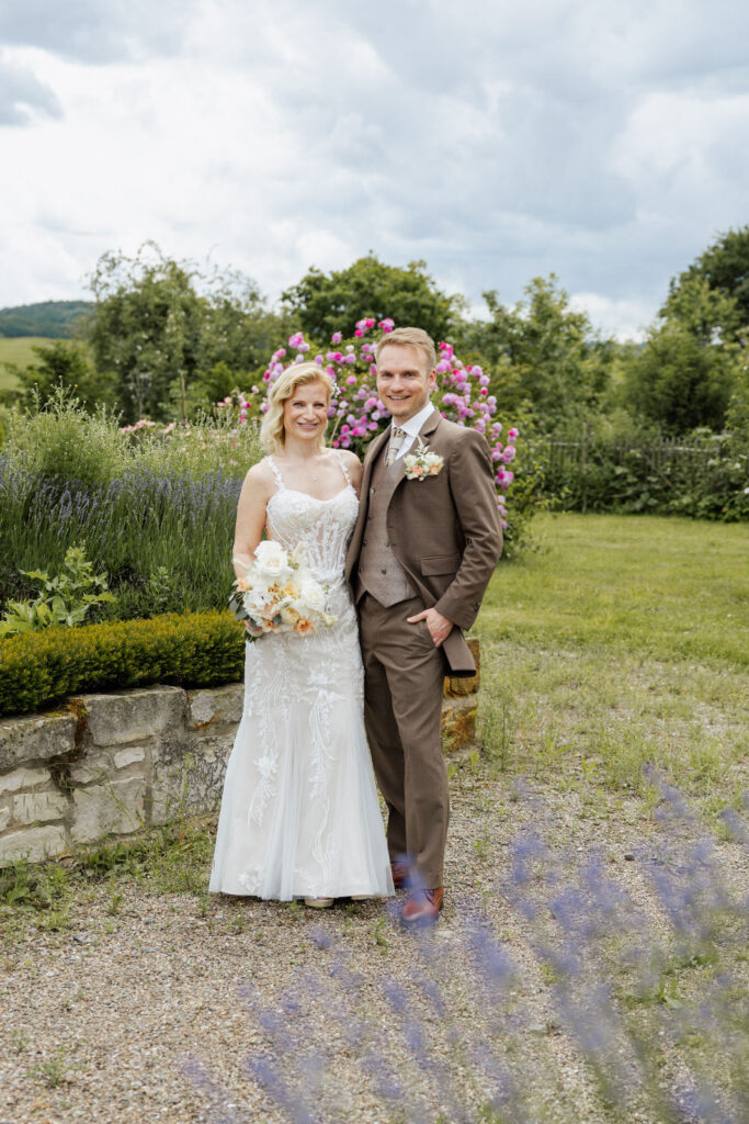 Brautpaar im Rosengarten des Ritterguts Remeringhausen bei einem romantischen Paarshooting. Die blühende Gartenanlage der Hochzeitslocation in Niedersachsen bietet eine wunderschöne Kulisse für exklusive Hochzeitsfotos. Hochzeitsplanung von Sophia von Aspern, von Aspern Weddings, in Hamburg, Hannover, Bremen und Niedersachsen. Foto: Sarah Prahm.