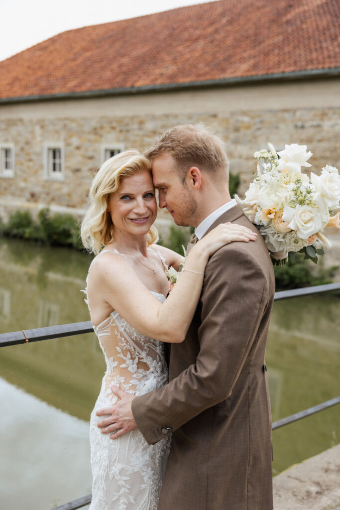 Brautpaar beim Paarshooting vor dem historischen Torhaus des Ritterguts Remeringhausen nahe Hannover. Die exklusive Hochzeitslocation bietet eine stilvolle Kulisse für emotionale Hochzeitsfotos. Hochzeitsplanung von Sophia von Aspern, von Aspern Weddings, in Hamburg, Hannover, Bremen und Niedersachsen. Foto: Sarah Prahm.