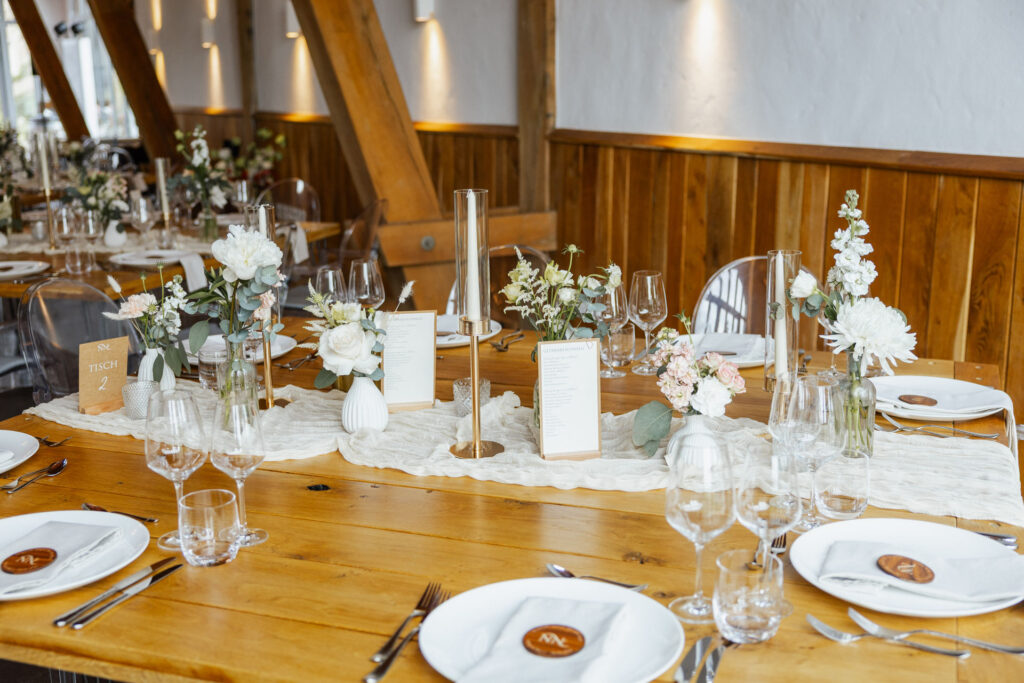 Stilvoll gedeckter Hochzeitstisch im Rittergut Remeringhausen mit eleganter Dekoration und hochwertigem Tischdesign. Die exklusive Hochzeitslocation nahe Hannover bietet den perfekten Rahmen für stilvolle Feiern. Hochzeitsplanung von Sophia von Aspern, von Aspern Weddings, in Hamburg, Hannover, Bremen und Niedersachsen. Foto: Sarah Prahm.